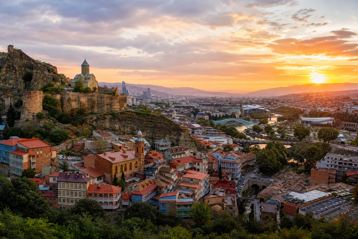 Sunset panorama of Tbilisi Old Town, Narikala Fortress, and the Kura River in Georgia.